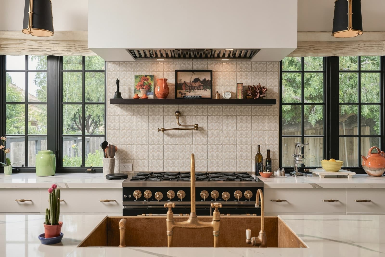 Kitchen with a black range, brass fixtures and steel-framed windows